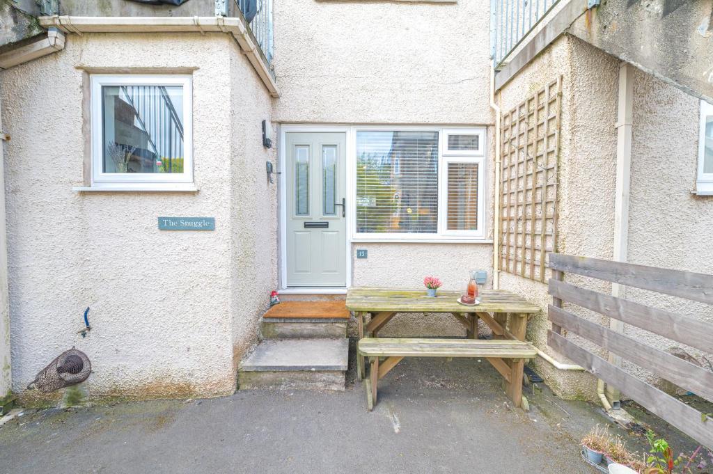 a wooden table in front of a house with a door at Couples getaway in central Windermere, ground floor flat with parking in Windermere