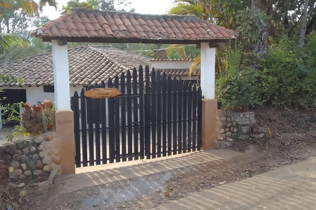 a black fence with a gazebo in front of a house at Departamento Raíces in Curití