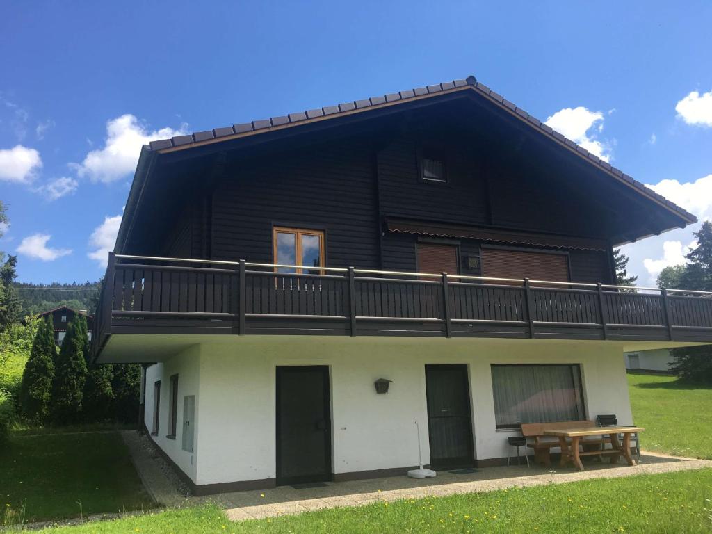 a house with a black roof and a balcony at Einfach entspannen in Arrach