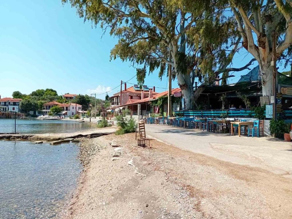 een strand met tafels en stoelen naast het water bij Katerina's SeaSide in Afissos