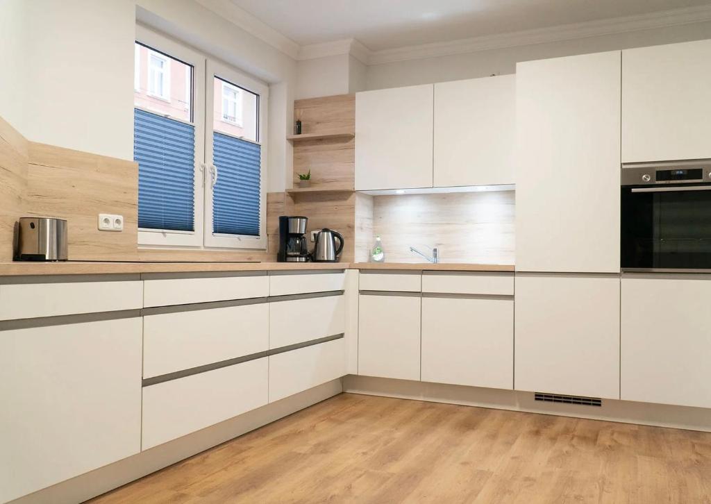 a white kitchen with white cabinets and a window at Annalena in Schwerin
