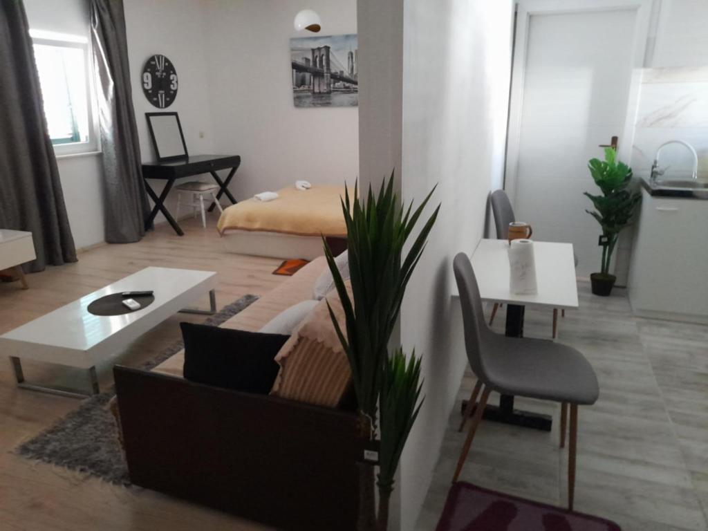 uma sala de estar com um sofá e uma mesa em Apartmani Dotur em Split