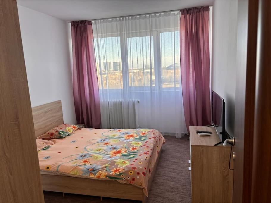 sypialnia z łóżkiem, telewizorem i oknem w obiekcie Apartament 2 camere Sector 1 w Bukareszcie