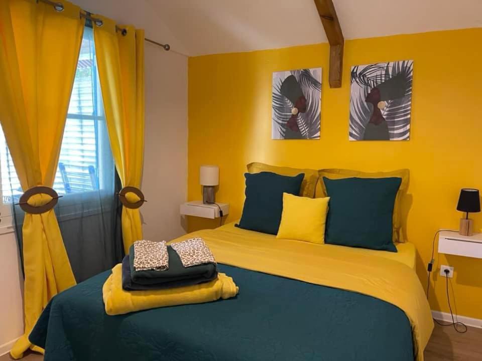 1 dormitorio con 1 cama de color azul y amarillo en Le Temps des prunes - 4 personnes, en Cilaos
