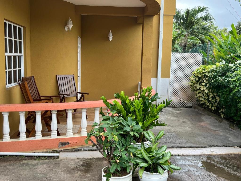 a porch of a house with two chairs and plants at Estuary Apartments 2B in Dunfermline