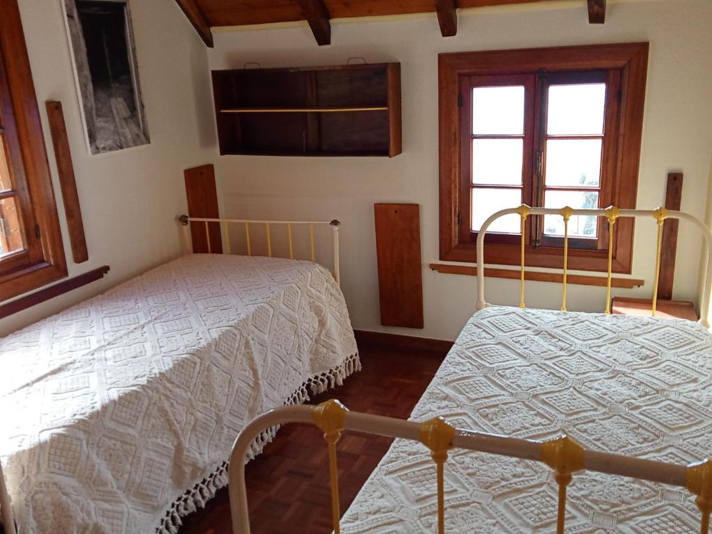 sypialnia z 2 łóżkami i oknem w obiekcie Casa Belojardim E Antiga Fábrica de Manteiga w mieście Arco da Calheta