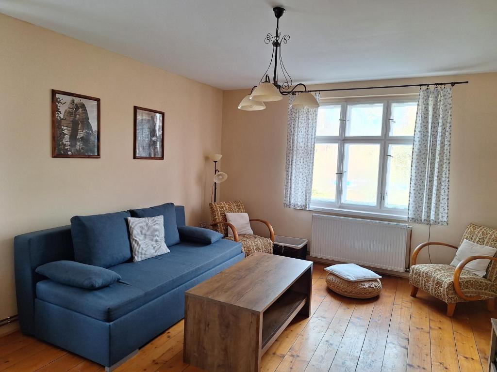 a living room with a blue couch and a table at Apartment 180 in Teplice nad Metují