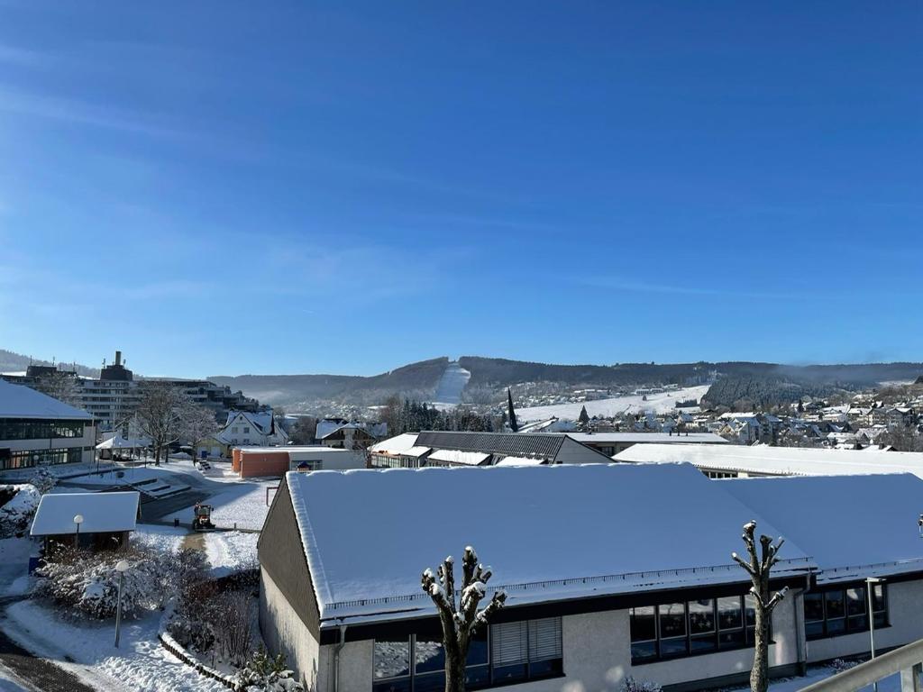 a city with snow on the roof of a building at Residenz Mühlenberg Typ A in Willingen