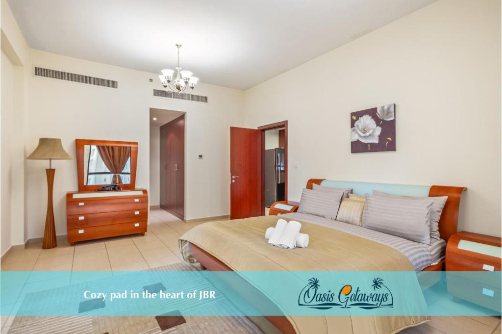 1 dormitorio con cama, tocador y espejo en Cozy pad in the heart of Dubai on JBR beach!, en Dubái