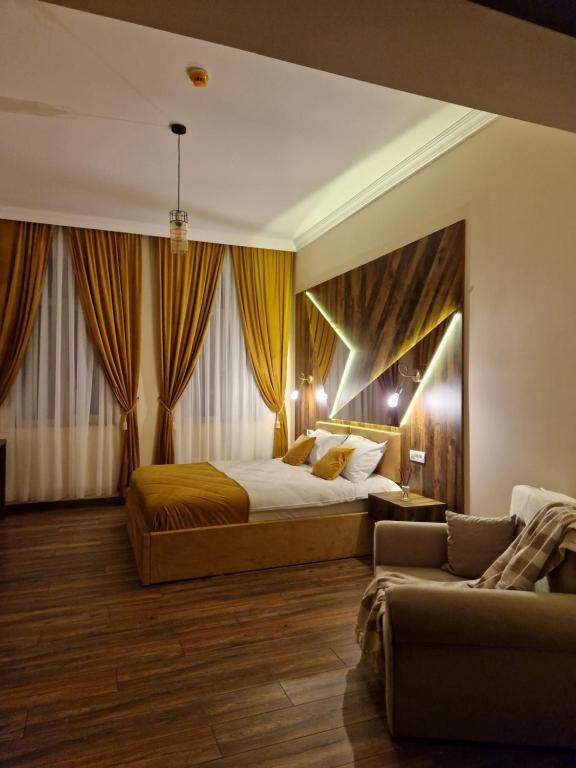 1 dormitorio con 1 cama grande y 1 sofá en Bizi House Accommodation 2, en Drobeta-Turnu Severin