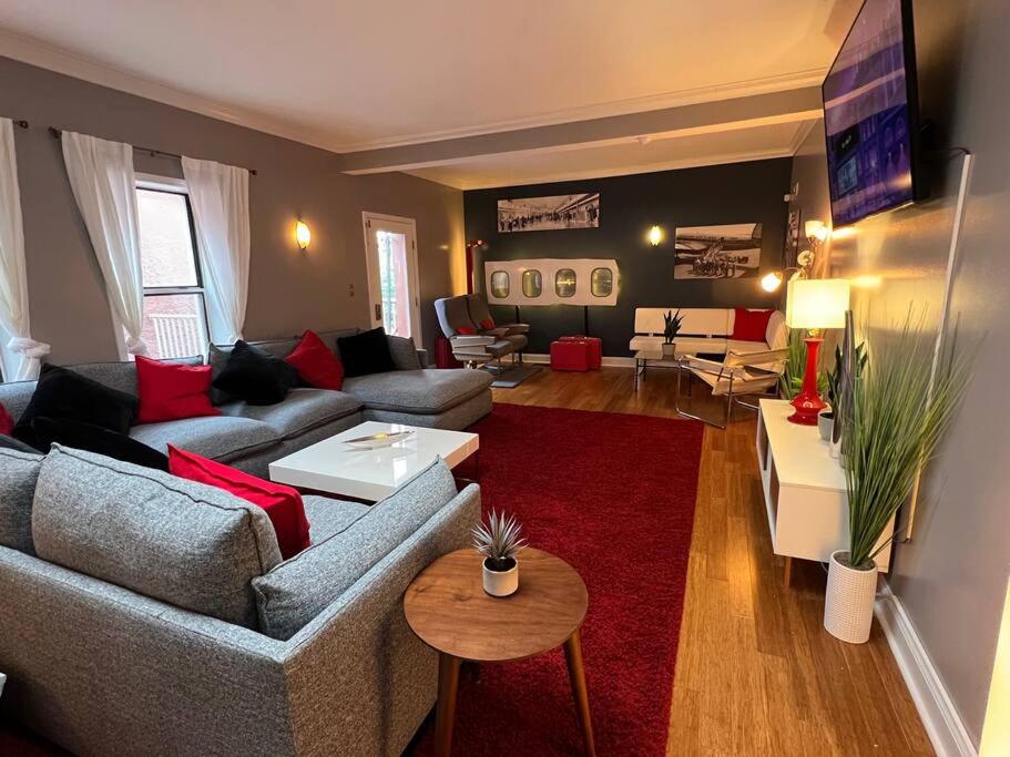 a living room with couches and a red rug at Coolest condo ever- Indy's best at your door step - Central Mass Ave! in Indianapolis