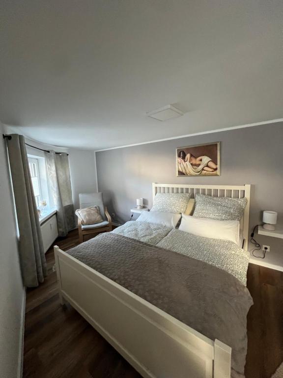 ein Schlafzimmer mit einem großen Bett und einem Stuhl in der Unterkunft Stadtzauber Apartments in Bad Neuenahr-Ahrweiler