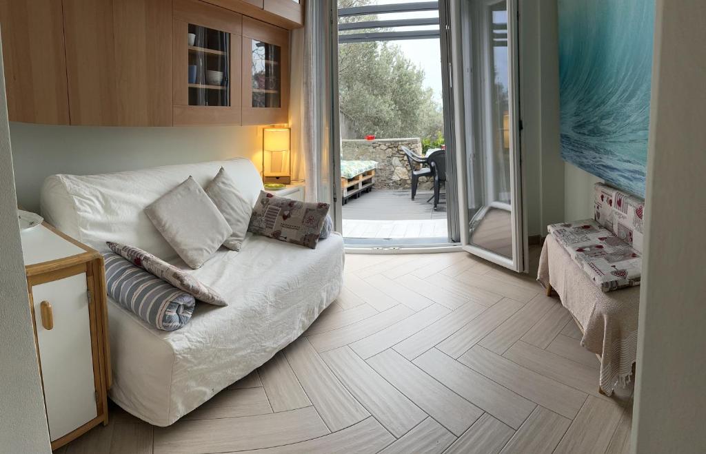 a living room with a couch and a sliding glass door at Casa del sasso in Bergeggi