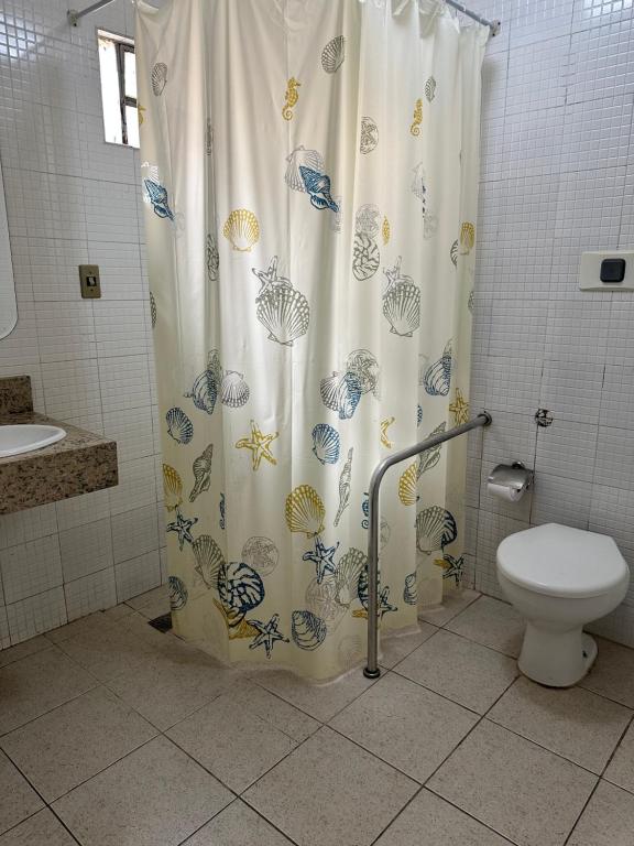 a bathroom with a shower curtain with a toilet at HOTEL AMADO in Aracaju