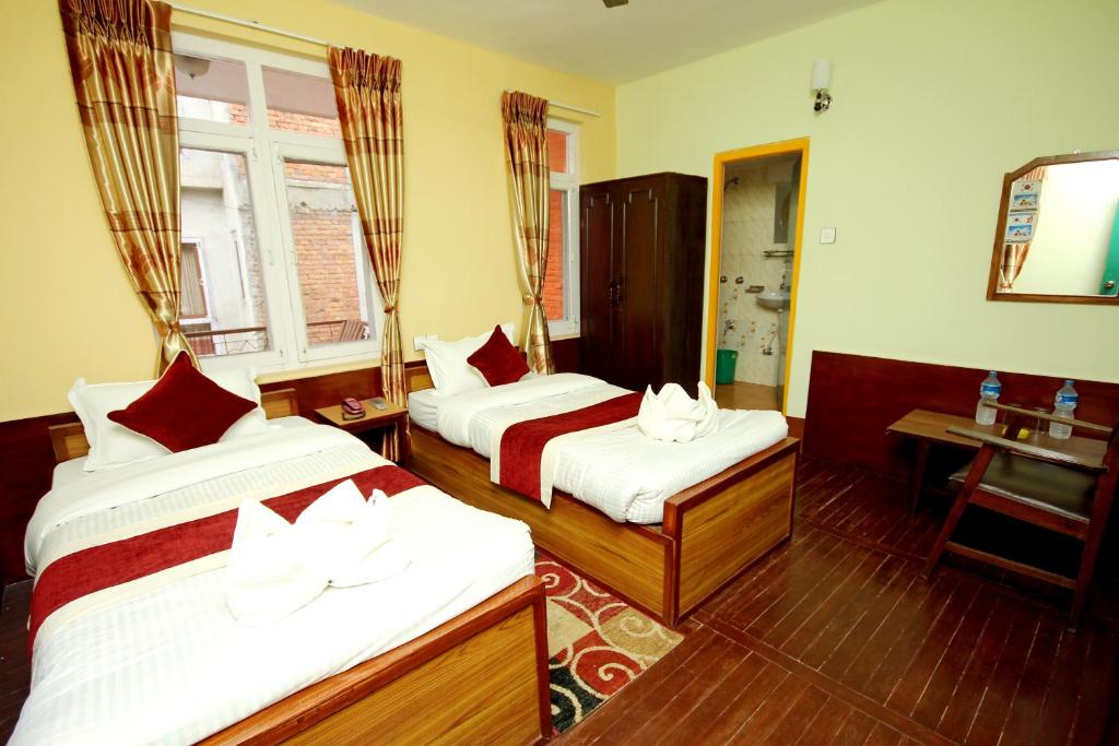 a hotel room with two beds and a window at hotel Backpackers inn in Kathmandu