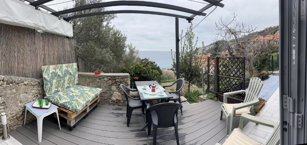 a patio with a table and chairs on a deck at Casa del sasso in Bergeggi