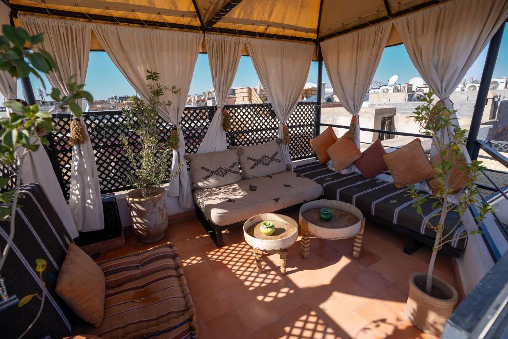 sala de estar con sofá en el balcón en Riad Olika, en Marrakech