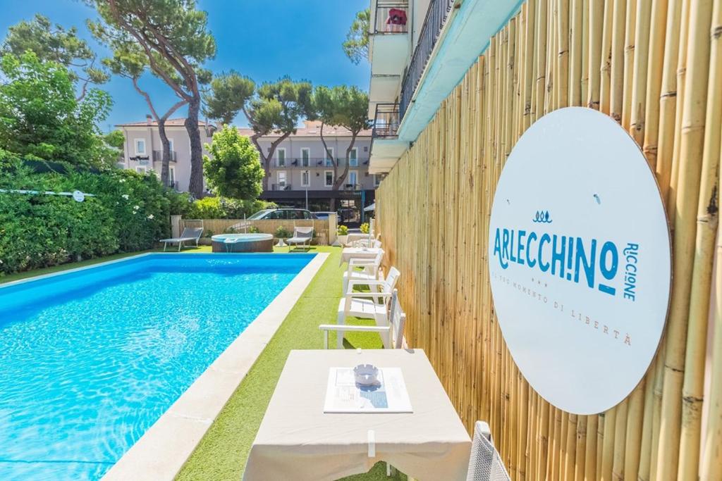 a sign on a wall next to a swimming pool at Hotel Arlecchino Riccione in Riccione