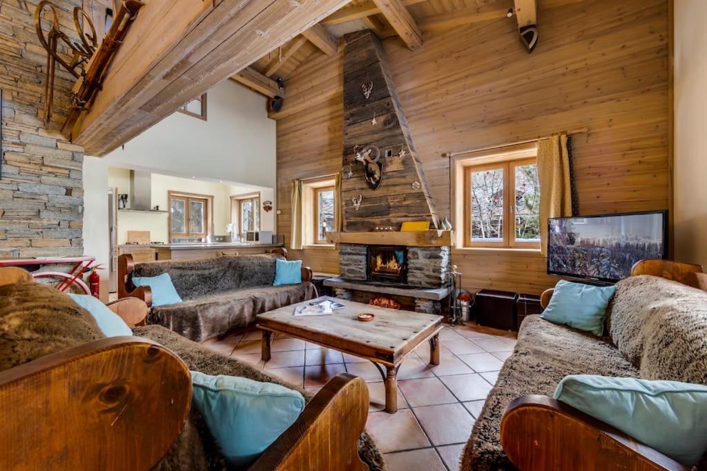 - un salon avec des canapés et une cheminée dans l'établissement Magnifique et Chaleureux Chalet à Val d'Isere, à Le Fornet