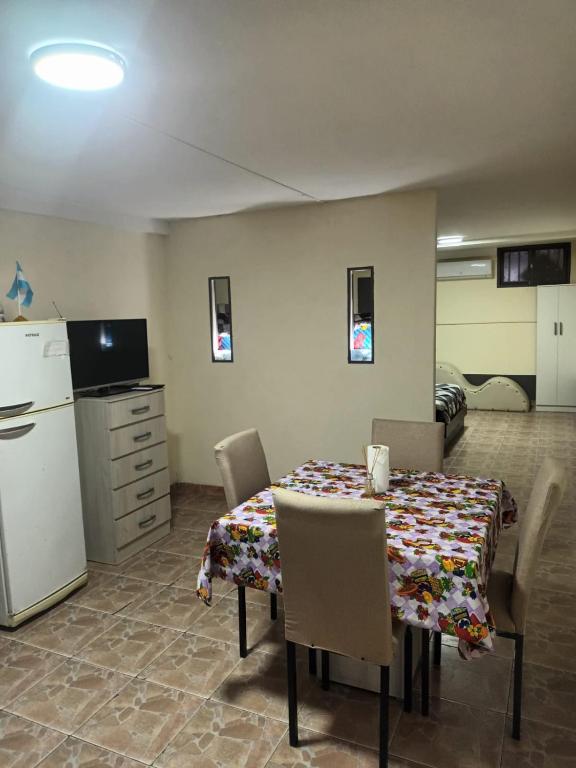 a dining room with a table with chairs and a refrigerator at la pipi in Las Heras