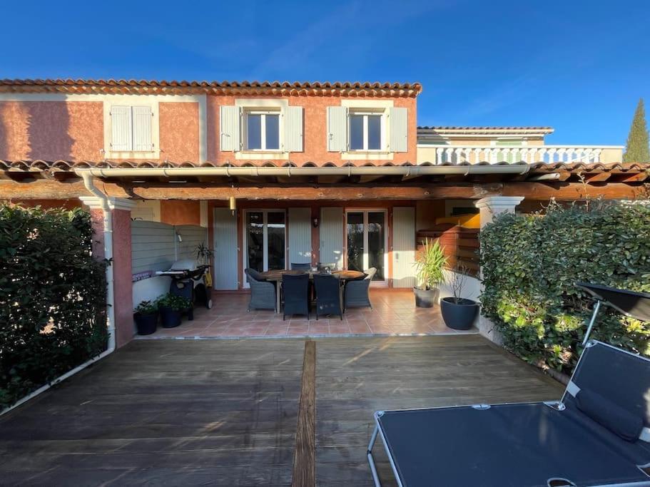 une maison avec un patio avec une table et des chaises dans l'établissement Villa avec vue panoramique, à Roquebrune-sur Argens