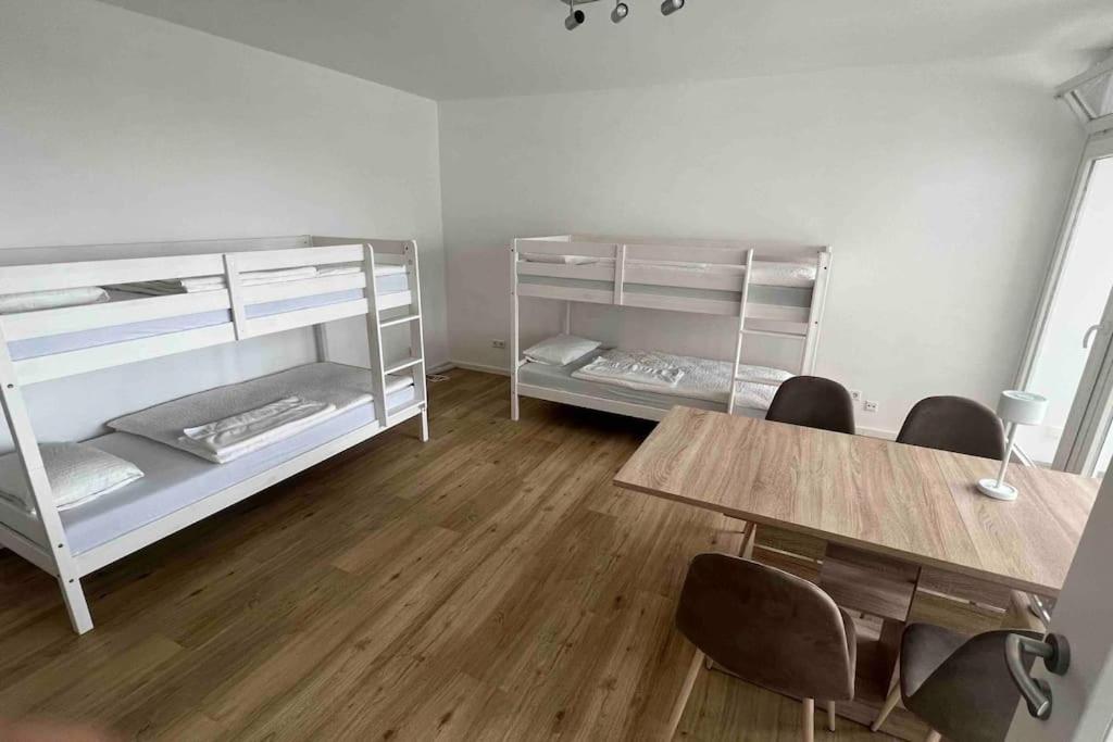 a room with bunk beds and a table and chairs at Apartment in Langenhagen-Airport-Hannover! contactless check-in in Hannover
