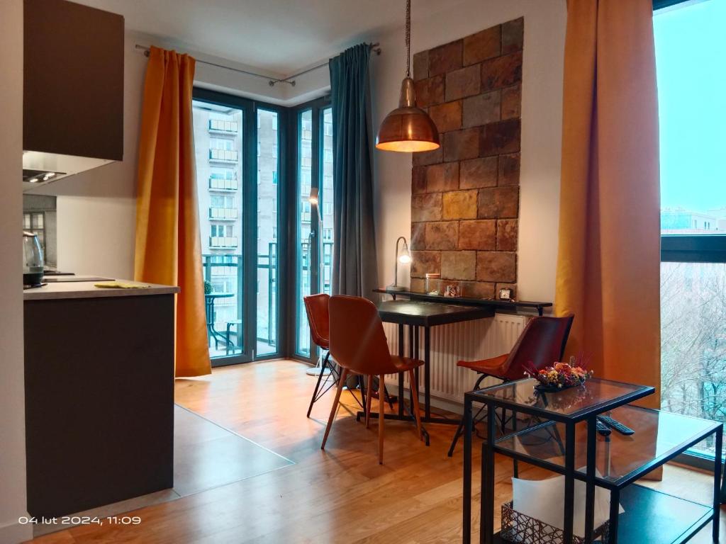 a kitchen and living room with a table and chairs at Uroczy Apartament Długie Ogrody 48 in Gdańsk