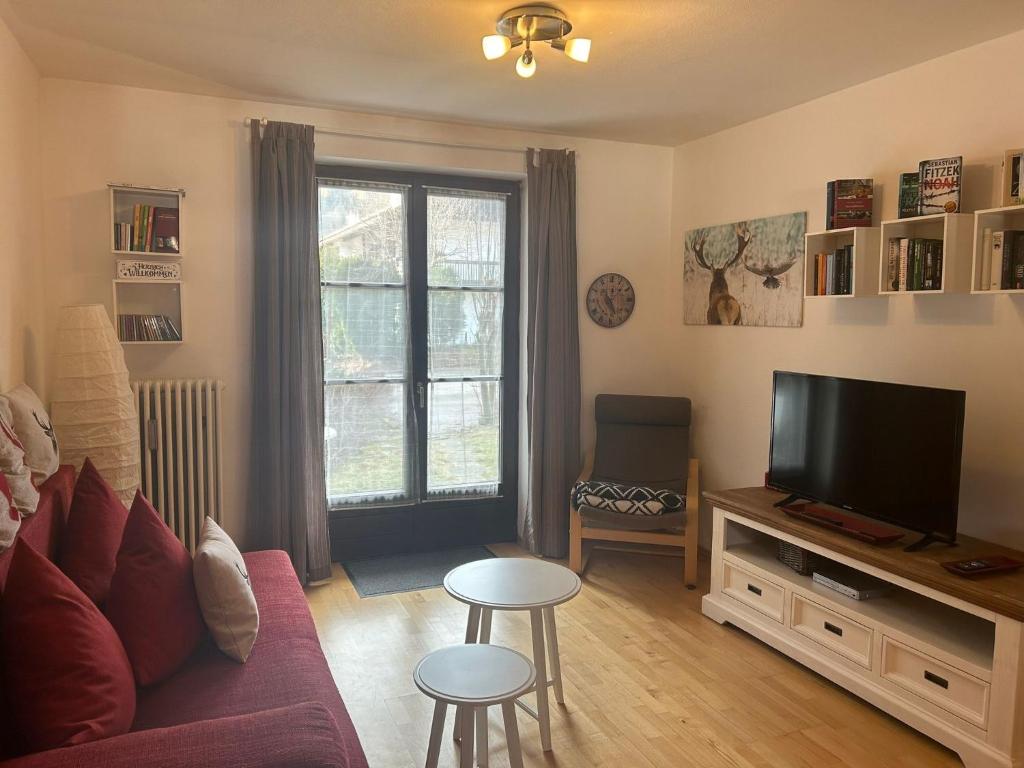 a living room with a couch and a tv at Ferienwohnung Carpe Diem - a89500 in Walchensee