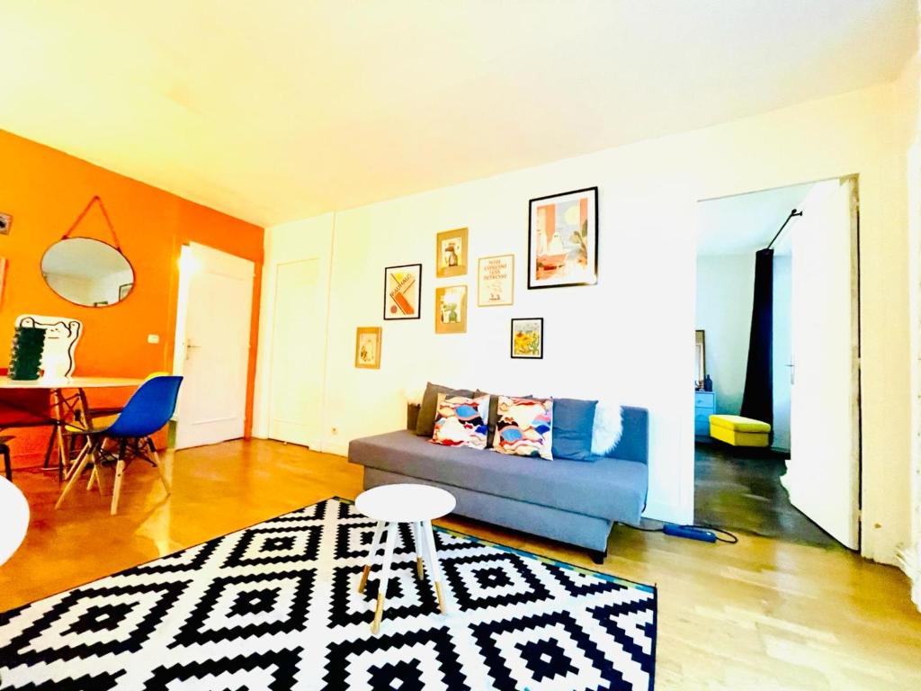 un salon avec un canapé et une table dans l'établissement Bel appartement Stade de France piscine olympique, à Saint-Denis