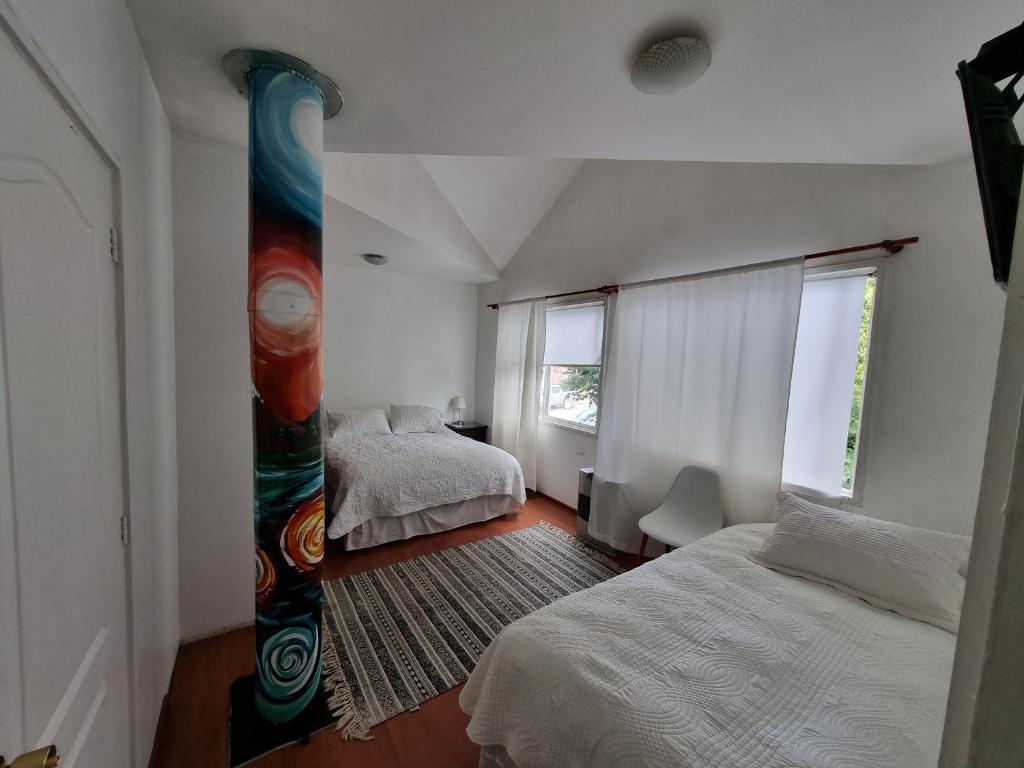 una camera con due letti e una grande finestra di Hostal Casa Arrayán a Coihaique