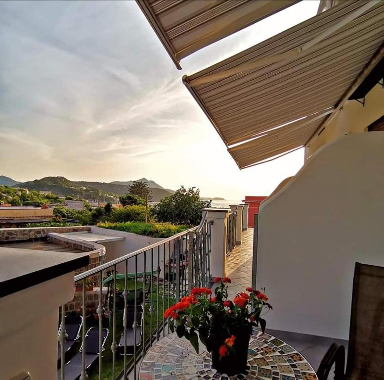 a balcony with a table with a vase of flowers on it at Tuttiacasaditeresa Rooms in Procida