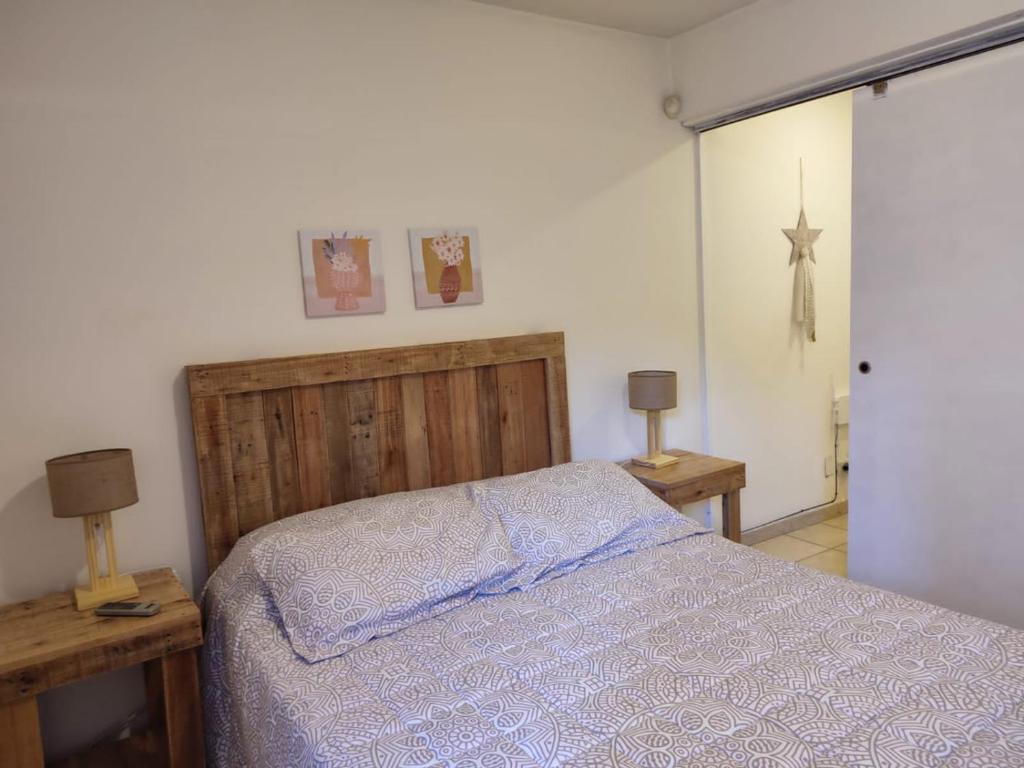 1 dormitorio con 1 cama, 2 mesas y 2 lámparas en Dpto Catedral en Salta
