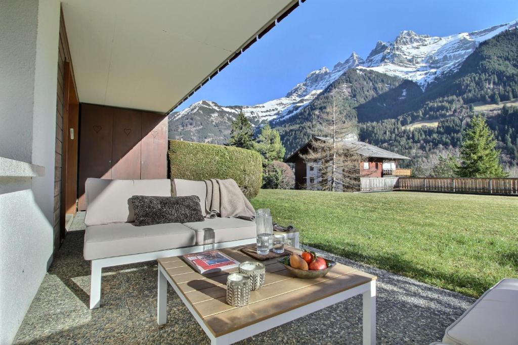 sala de estar con sofá, mesa y montañas en Garden, Terrasse, Relax en Champéry