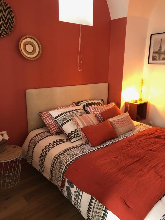 a bedroom with a bed with red walls at Charmant appartement, 1 chambre, en centre historique in Annonay