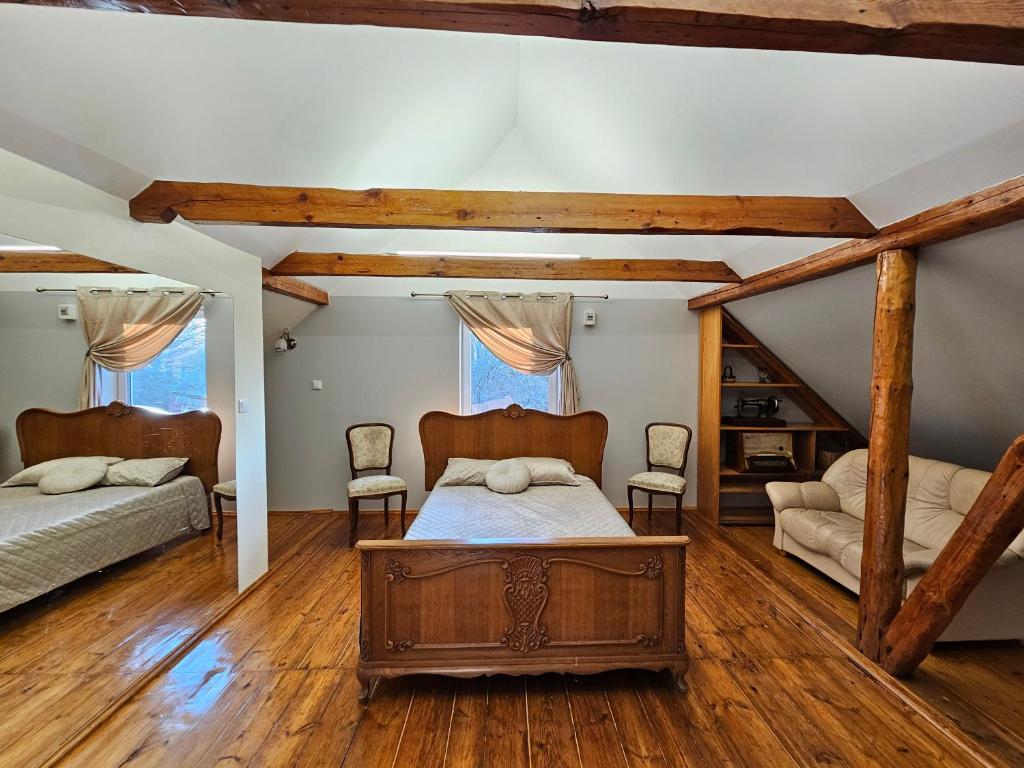 a bedroom with two beds and a wooden floor at Ziediņi in Auciems
