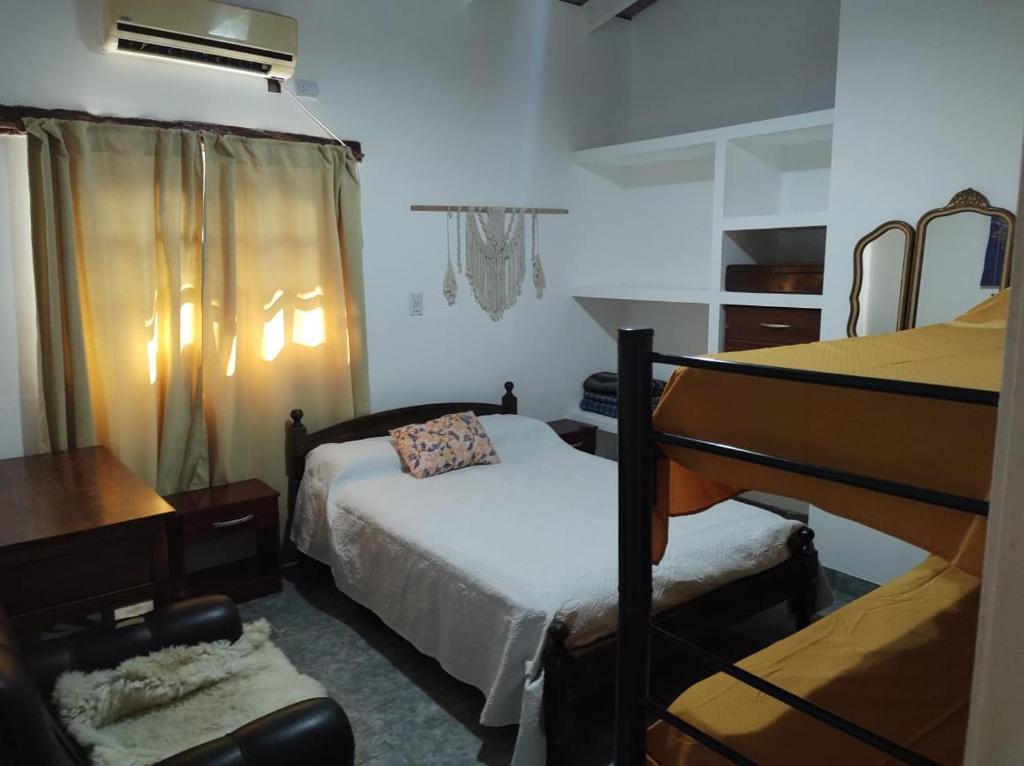 a bedroom with a bed and a desk and a piano at Sueño de Termas in Termas de Río Hondo