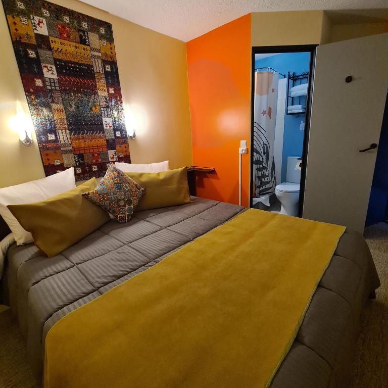 Una cama o camas en una habitaci&oacute;n de H&ocirc;tel L&#39;Etoile A&eacute;roport - A61