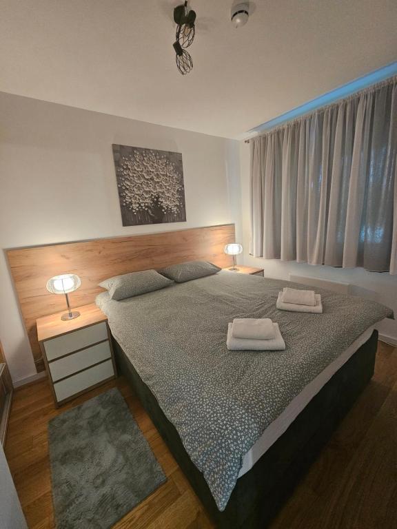 1 dormitorio con 1 cama grande y 2 toallas. en Apartman Novak en Jahorina