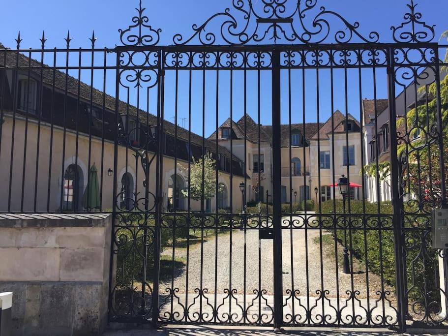 a black iron gate with houses in the background at Bel appart au bord de l’eau proche gare avec wifi in Auxerre