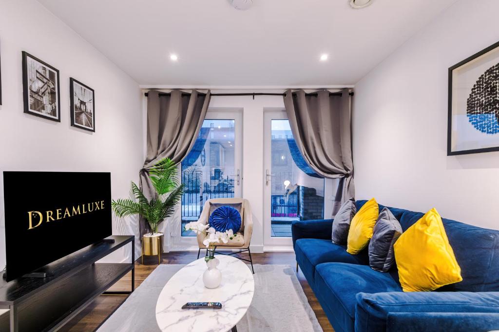 a living room with a blue couch and a tv at Waterhouse Suite - Modern 2 Bed in Manchester City Centre- Perfect for Family, Business and Leisure Stays by Dreamluxe in Manchester