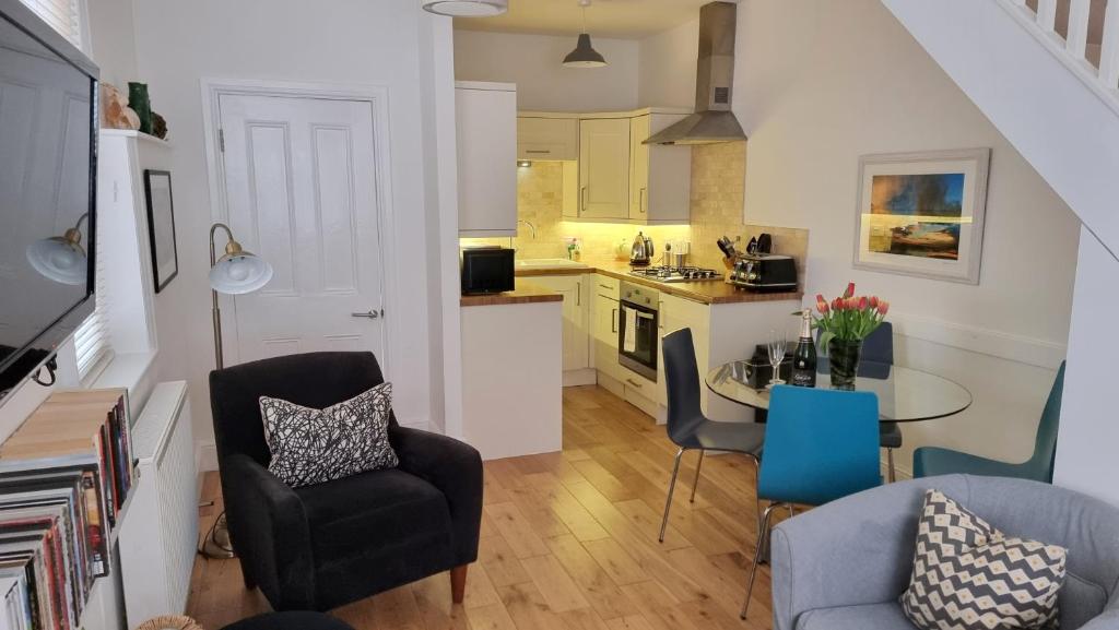 a kitchen and living room with a table and chairs at Little Sussex House in Rye