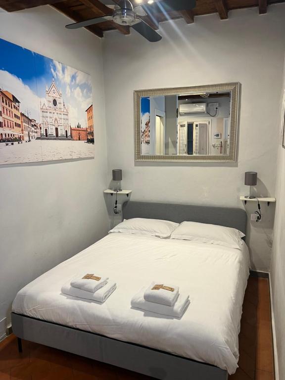 Un dormitorio con una cama blanca con una foto en la pared en I'Biancone, en Florencia