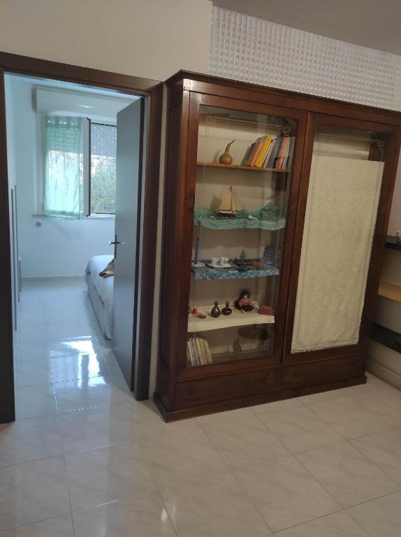una stanza con un mobile in legno con scarpe di Residence Il Pavone a Sassari