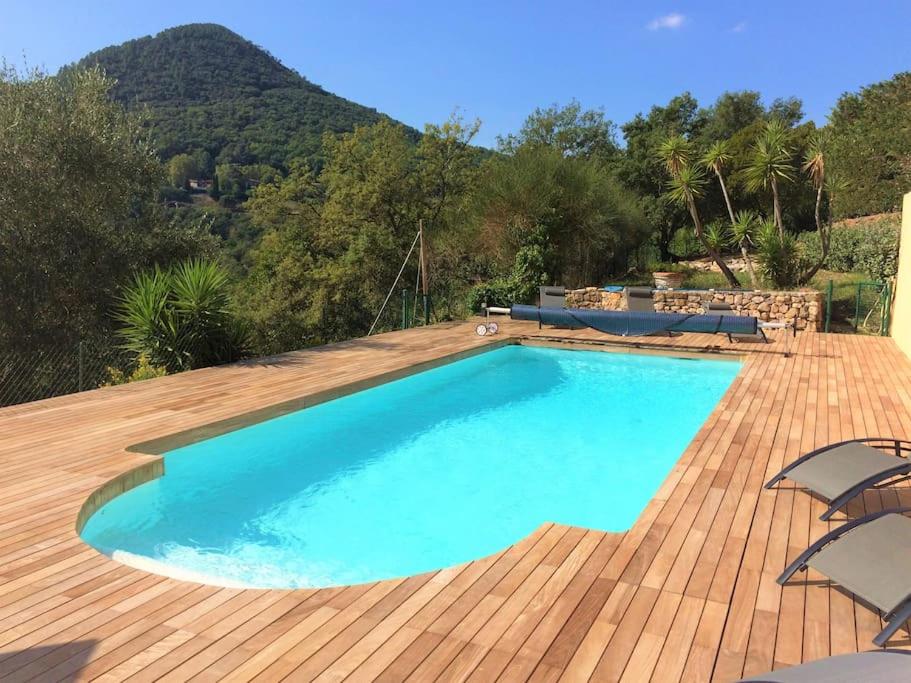 - une piscine sur une terrasse avec une montagne en arrière-plan dans l'établissement Superbe appartement dans villa provençale piscine et jardin, à Fréjus
