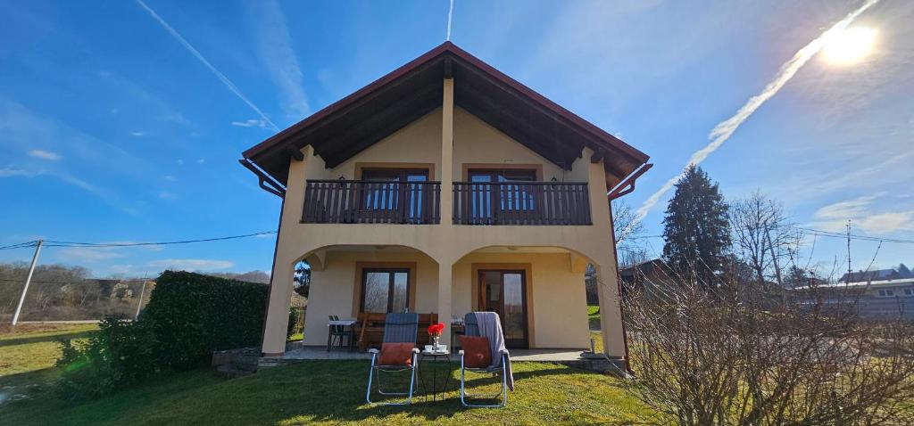 a small house with a balcony and some chairs at Holiday house and apartments Vale in Duga Resa