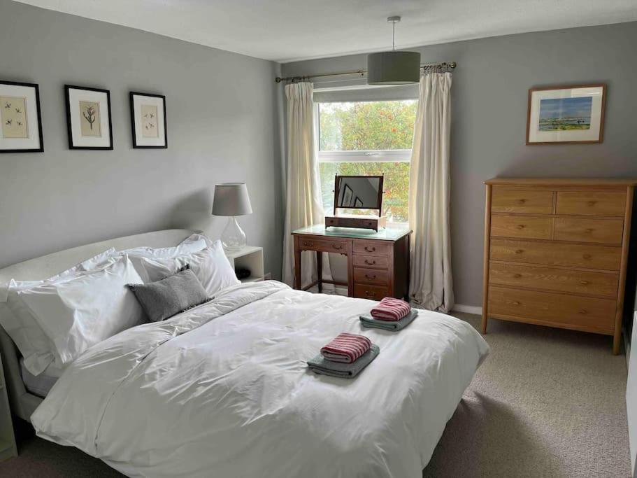 a bedroom with a bed and a desk with a laptop at Bright flat in the heart of Chichester in Chichester