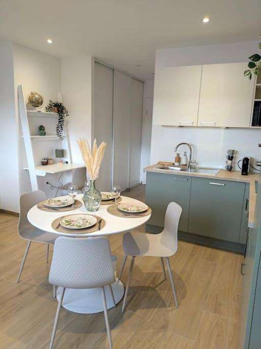 a kitchen with a table and chairs in a room at Le COCON, appartement moderne et cosy in Dinsheim