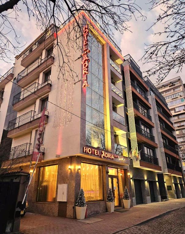 a hotel with a sign on the side of a building at Hotel Adria in Sofia