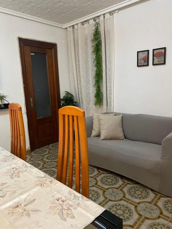 een woonkamer met een bank en een tafel en stoelen bij Valencia Well Located Shared Apartment in Valencia