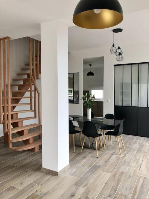 une salle à manger avec une table et des chaises et un escalier dans l'établissement Grange 5 minutes du centre-ville et gare avc wifi, à Auxerre